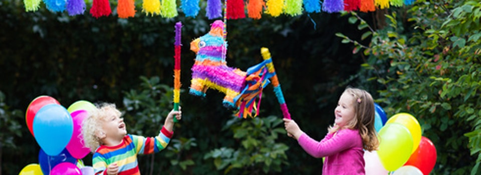 Enfant s'amusant avec une pinata et des guirlandes